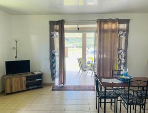 sala de estar con TV y mesa con sillas en Lokai house, en Bora Bora