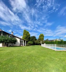 un gran patio con una valla y una casa en María Bonita Chalet Villa independiente con piscina y amplio jardín, en Cabezón de la Sal