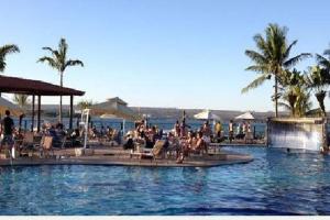 una piscina con gente sentada en sillas en el agua en Charmoso Flat Lake Side en Brasilia