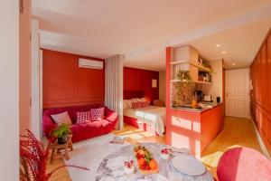 a living room with a red couch and a bed at As Vizinhas Boutique Apartments in Porto