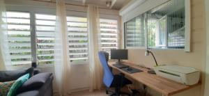una oficina con escritorio, ordenador y silla en Appartement "grand Hibiscus" jardin privé, en Le Lamentin