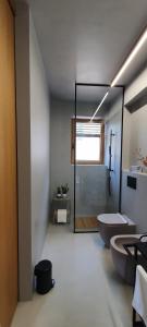 a bathroom with a shower and a toilet and a tub at HOUSE G in Dekani