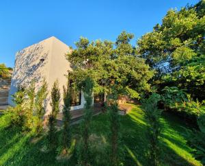 un bâtiment avec une cour plantée d'arbres et d'herbe dans l'établissement HOUSE G, à Dekani