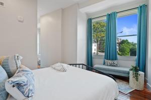 a bedroom with a bed and a window with blue curtains at The Roxanne 1 - Chic One Bedroom Townhome in OTR in Cincinnati