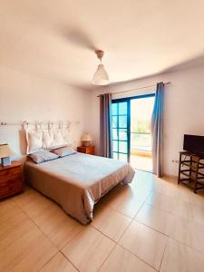 a bedroom with a bed and a large window at Casa Cris in La Lajita