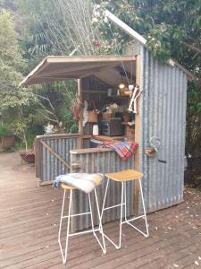 a table and two stools outside of a shed at Cabins on Tudor bed & breakfast in Motueka