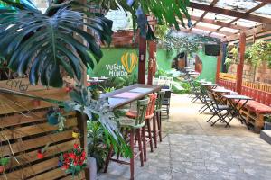 un restaurante al aire libre con mesas, sillas y plantas en Mangifera Hostel, en Grecia