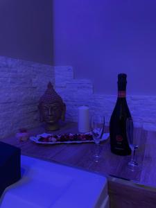 a bottle of wine and two glasses on a table at B&B New Paris & Suite in Taranto