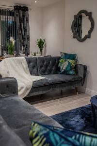 a living room with a gray couch with pillows at BV Comfy Spacious 3 Bedroom House At Tatton Street Manchester in Manchester