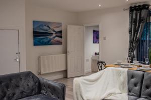 a living room with a table and a couch at BV Comfy Spacious 3 Bedroom House At Tatton Street Manchester in Manchester