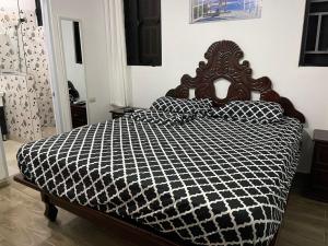 Schlafzimmer mit einem Bett mit einer schwarzen und weißen Bettdecke in der Unterkunft Villa Flor 2022 in Los Plátanos