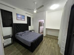 Schlafzimmer mit einem Bett mit einer schwarzen und weißen Bettdecke in der Unterkunft Villa Flor 2022 in Los Plátanos