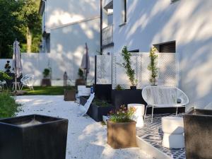 patio ze stołem, krzesłami i doniczkami w obiekcie MOYÏ w mieście Basse-Goulaine