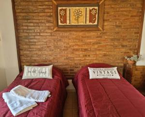 two beds in a room with a brick wall at Usuy SN in San Nicolás de los Arroyos