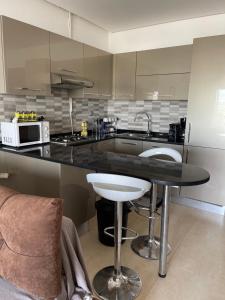 a kitchen with a black counter top and a table at PALM LAKE RESORT FOLLA in Monastir