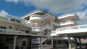 un gran edificio blanco con balcones blancos. en Las Palmas Hotel, en Corozal