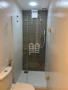 a bathroom with a glass shower with a toilet at Melhor localização Leblon, apartamento reformado in Rio de Janeiro