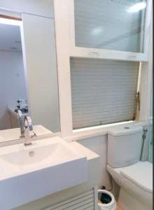 a bathroom with a sink and a toilet and a mirror at Melhor localização Leblon, apartamento reformado in Rio de Janeiro