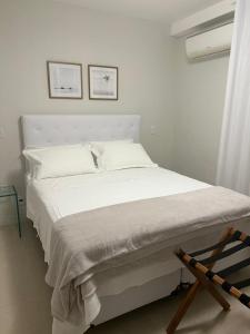 a white bed with white sheets and pillows in a bedroom at Melhor localização Leblon, apartamento reformado in Rio de Janeiro