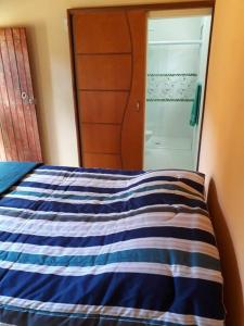 a bedroom with a blue and white bed and a mirror at Recanto do Ipê in Extrema