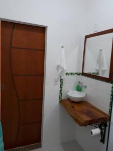 een badkamer met een wastafel en een spiegel bij Recanto do Ipê in Extrema