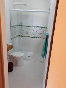 a white bathroom with a toilet and a shower at Recanto do Ipê in Extrema