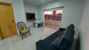 ein Wohnzimmer mit einem blauen Sofa und einem TV in der Unterkunft Residencial Baldissera e Zeni in Machadinho
