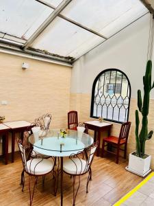 una habitación con mesas, sillas y un cactus en Imperial Inn Hospedaje Turistico, en Lima