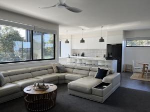 uma sala de estar com um sofá e uma mesa em Luxury on Bayview Wifi Linen included em Inverloch