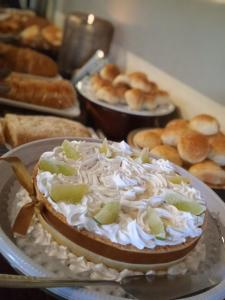 un pastel con crema batida y limas en una mesa en Pousada Casa Grande, en Pirenópolis
