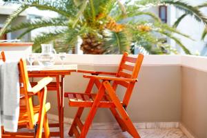 a table and two chairs at a balcony with a palm tree at Casa Maria Hotel Apts in Platanias