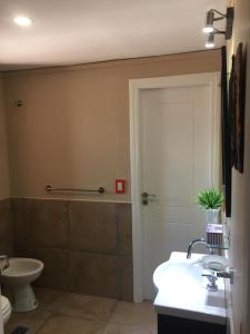 baño con aseo, lavabo y puerta en Cabañas Los 4 elementos - Uspallata en Las Heras