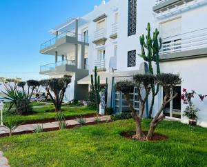 a white building with trees in front of it at Melrose Beαch Aρραrt Pοοl Vieω in Casablanca