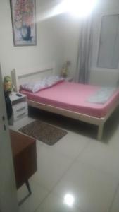 a bedroom with a pink bed and a desk at Casa Temporada - 2 Quartos in Torres
