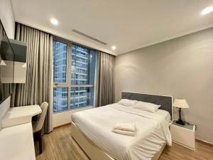 - une chambre avec un lit blanc et une grande fenêtre dans l'établissement Vinhomes Binh Thanh Official Luxury Apartment, à Hô-Chi-Minh-Ville