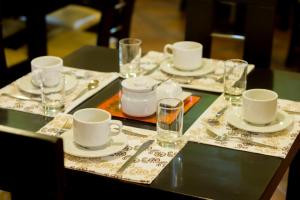 a table with plates and cups and glasses on it at Mosoq Inn in Puno