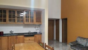 une cuisine avec des armoires en bois et une table en bois dans l'établissement Casa de Campo, à San Rafael