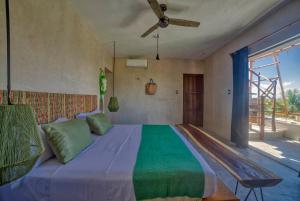 - une chambre avec un grand lit et un ventilateur de plafond dans l'établissement Hotel Boutique Can Cocal El Cuyo, à El Cuyo