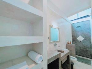 a bathroom with a sink and a toilet and a mirror at Salt villas Gili Air in Gili Air