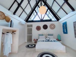 a bedroom with a large white bed and a skylight at Salt villas Gili Air in Gili Air
