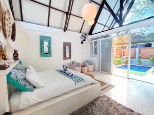 a bedroom with a bed and a large window at Salt villas Gili Air in Gili Air
