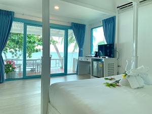 a bedroom with a large bed with blue drapes at Sand Sea Beach Resort in Lamai