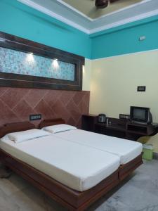 een slaapkamer met een groot bed en een televisie bij Krishna Lodge in Tiruchchirāppalli