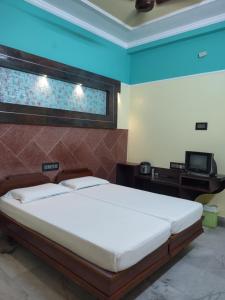 a bedroom with a large bed and a television at Krishna Lodge in Tiruchchirāppalli