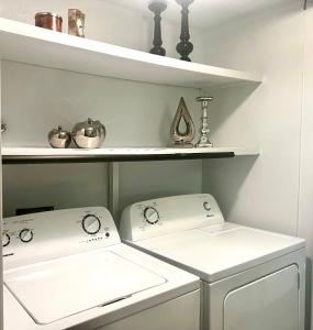 two washing machines in a laundry room with shelves at Luxurious Bungalow in Payson in Payson
