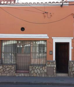 薩爾塔的住宿－SUMAQ WASICHA SALTA，一座橙色的建筑,设有铁窗和门