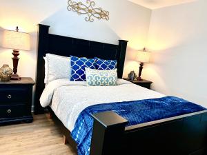 a bedroom with a bed with a blue comforter and two lamps at Luxurious Bungalow in Payson in Payson