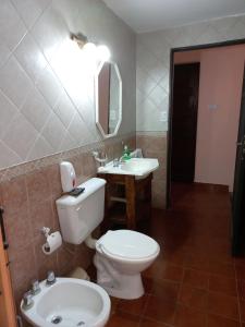 a bathroom with a white toilet and a sink at SUMAQ WASICHA SALTA in Salta