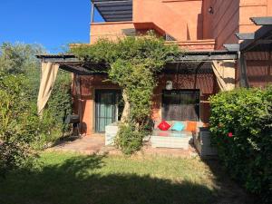een huis met een veranda met een bank in de tuin bij atlas golf resort marrakech " Maison à 03 chambres avec jardin privé " in Marrakesh