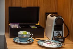 a cup and plates on a table with a microwave at The Langlands Hotel in Invercargill